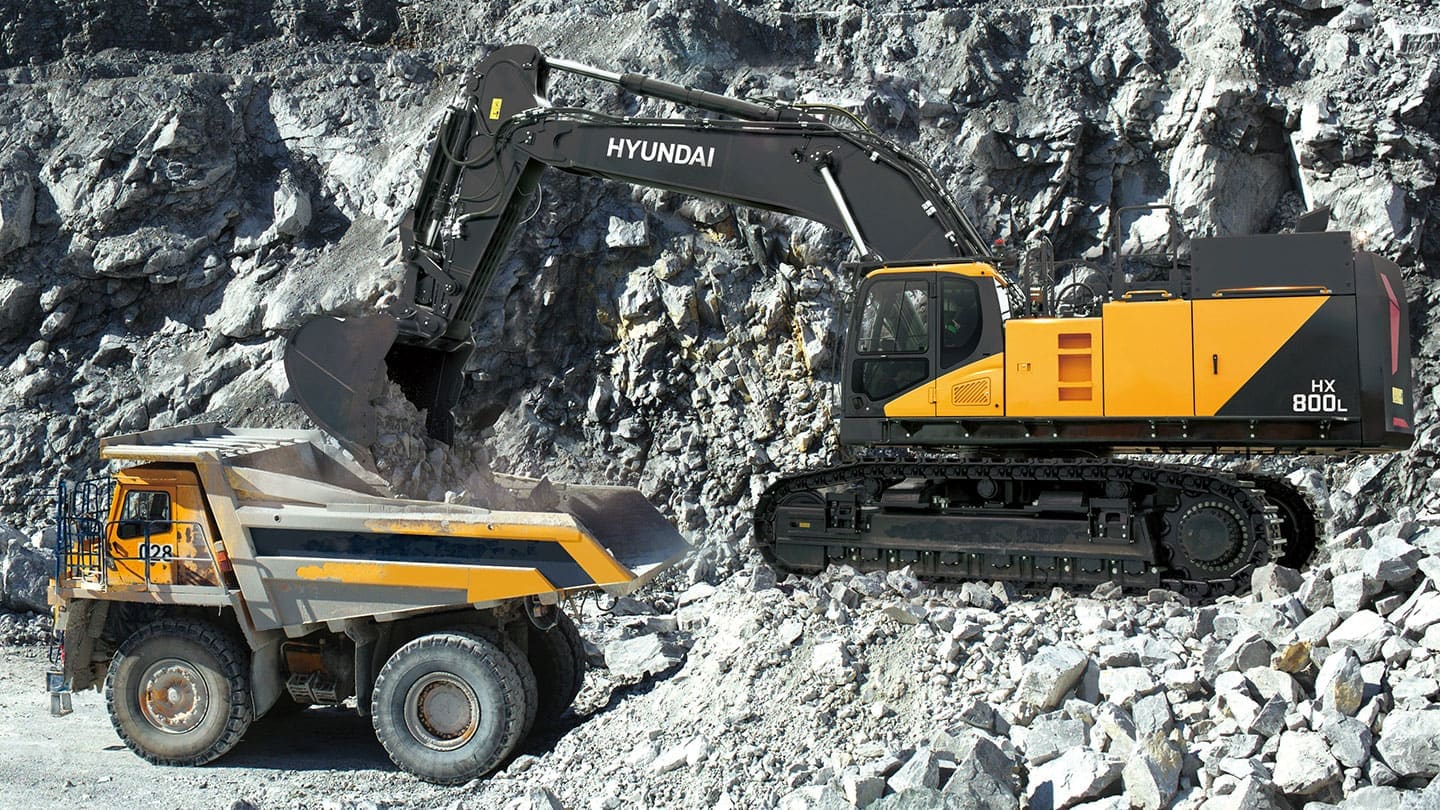 Hyundai excavator loading rock into a mining dump truck at an open-pit mine